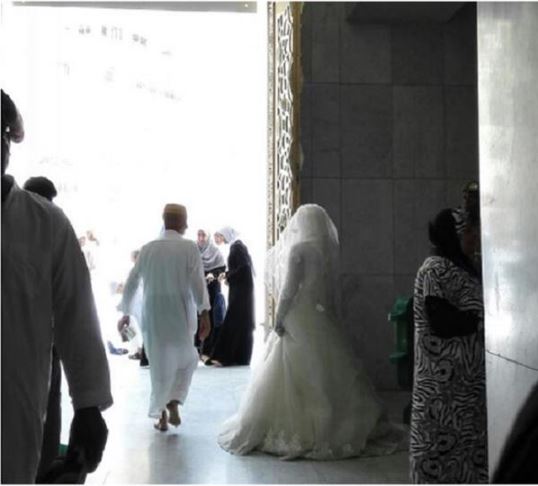 عروس تحاول دخول المسجد الحرام بفستان الزفاف