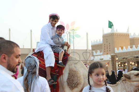 بالصور ..تجربة ركوب الإبل تستهوي أطفال الجنادرية