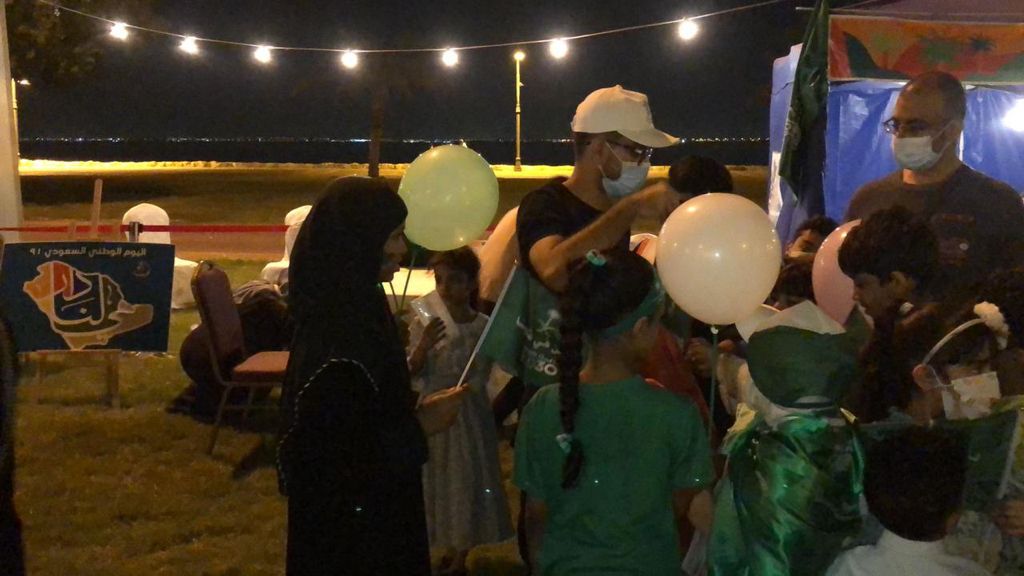 بالصور.. توزيع 5000 علم ووشاح بالقطيف بمناسبة اليوم الوطني